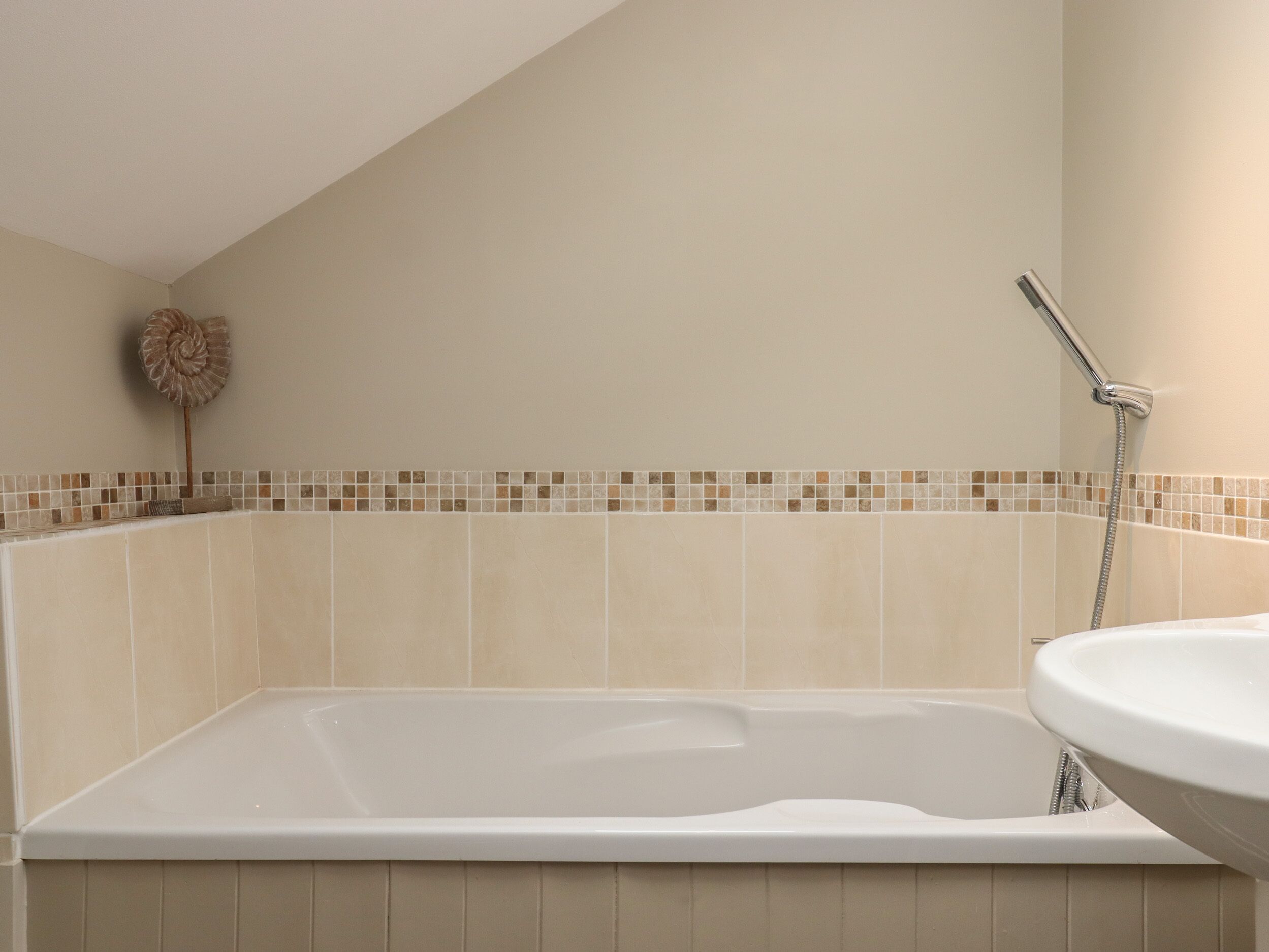 A bathroom with a bathtub, a shower, and a sink.
