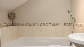 A bathroom with a bathtub, a shower, and a sink.