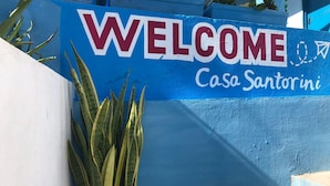 A blue and white sign with "WELCOME" and "Casa Santorini" written on it. - HOSTAL CASA SANTORINI (Cartagena)