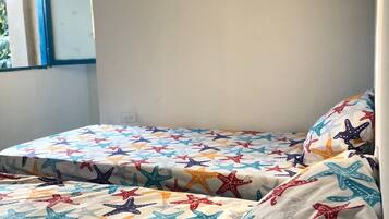 Una habitación con dos camas, cada una con un edredón estampado con motivos de estrellas de mar.