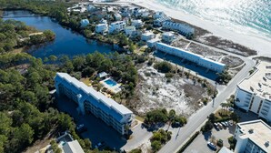 An aerial view of a coastal resort with multiple buildings, a beach, and a marina. - 30-A Loft with Gulf Views (Santa Rosa Beach)
