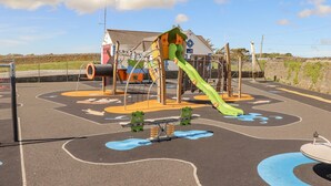 A playground with a slide, climbing structures, and a fenced area. - Cloughoge House (Kilrush)