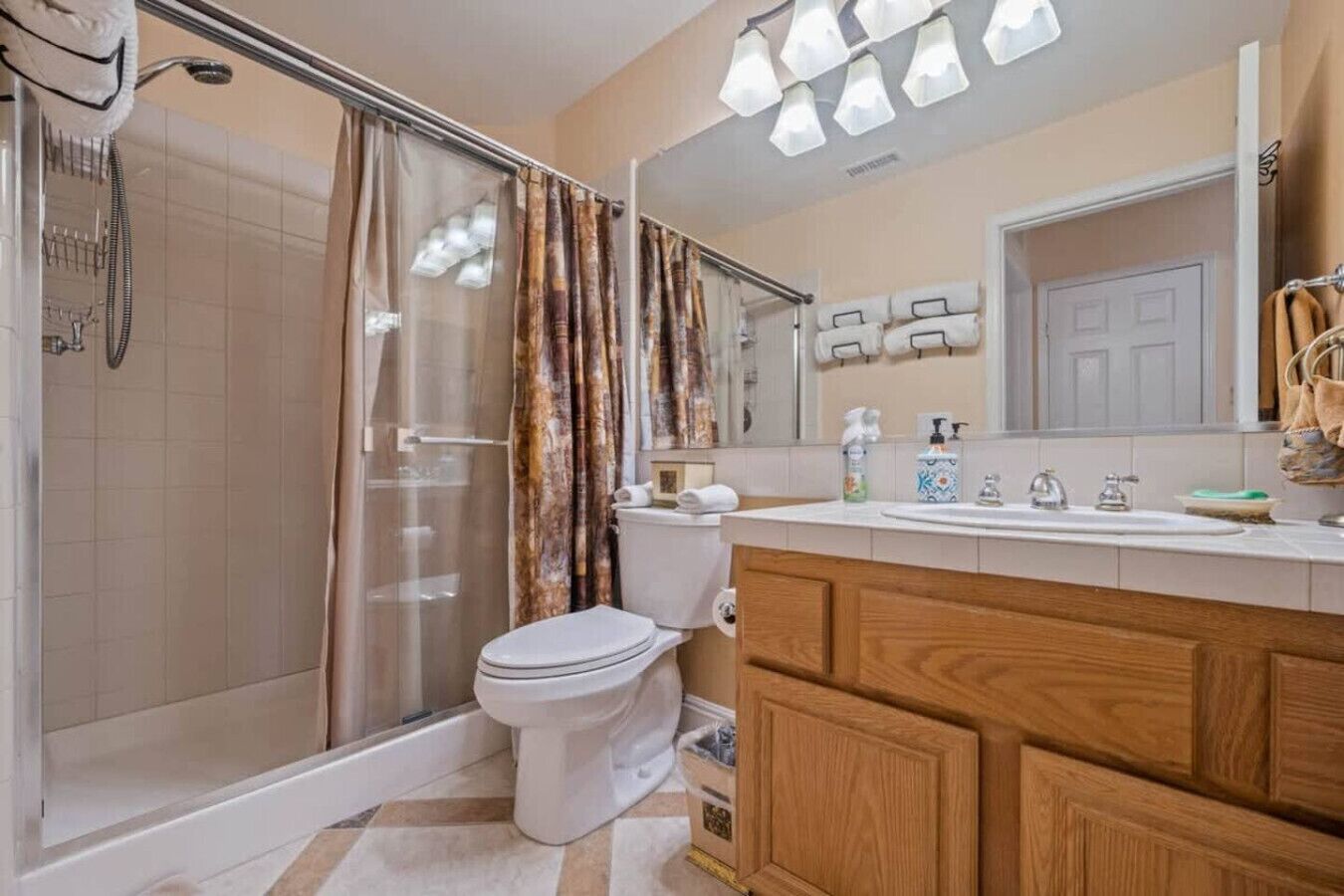 A bathroom with a shower, toilet, and vanity.