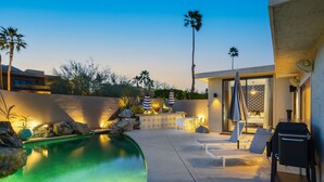 A pool area with lounge chairs, a grill, and a bar area with umbrellas. - NEW! Private Pool & Mountain Views! (Palm Springs)