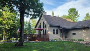 A modern two-story house with a covered deck, a garage, and a well-maintained lawn. - Adventure in the Blue Hills! Great for Hiking, ATV's 
 snowmobiling & hunting (Weyerhaeuser)