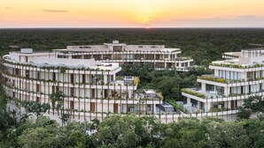 A modern, circular building complex surrounded by dense forest. - Mistiq Temple II  (Tulum)