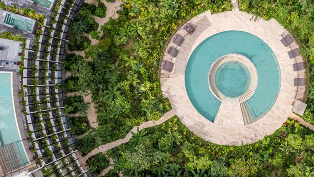 An aerial view of a resort with a central circular pool, surrounded by lush greenery and multiple swimming pools. - Mistiq Temple II  (Tulum)