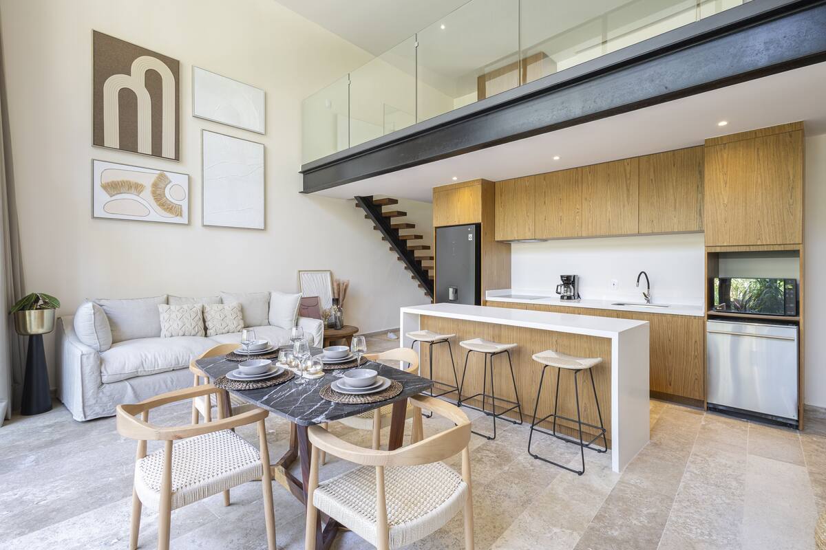 A modern kitchen with a central island, wooden cabinets, and a built-in refrigerator.