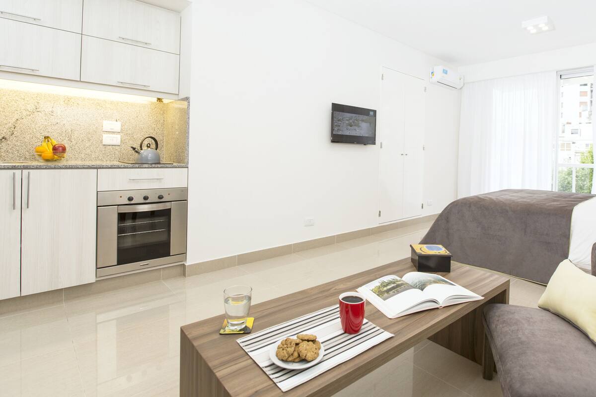 Un appartement moderne comprenant une cuisine, un coin repas et un salon.
