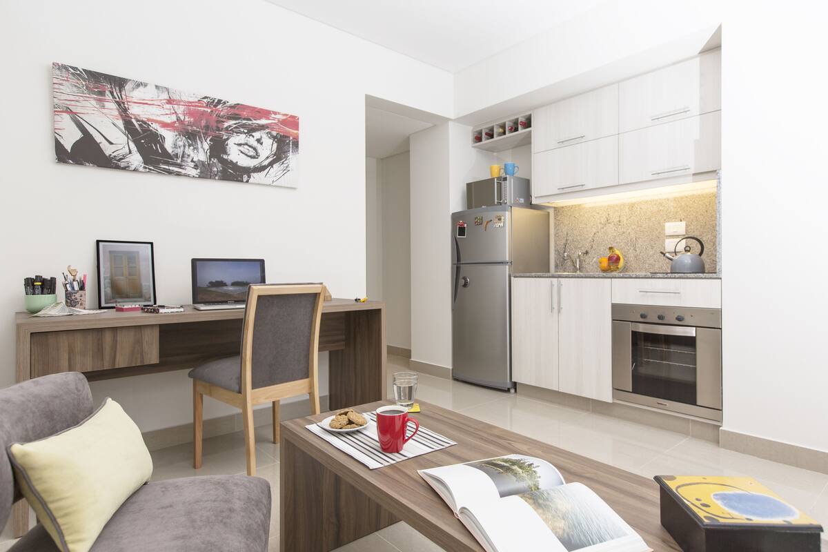 Un appartement moderne comprenant une cuisine, un coin repas et un salon.
