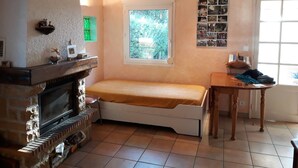 A room with a bed, a fireplace, a window, and a small table. - Holiday Home 'Frejus' with Shared Pool, Shared Terrace and Air Conditioning (Frejus)
