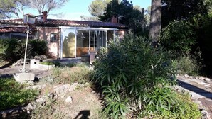 A house with a glass enclosure, a patio, and surrounding vegetation. - Holiday Home 'Frejus' with Shared Pool, Shared Terrace and Air Conditioning (Frejus)