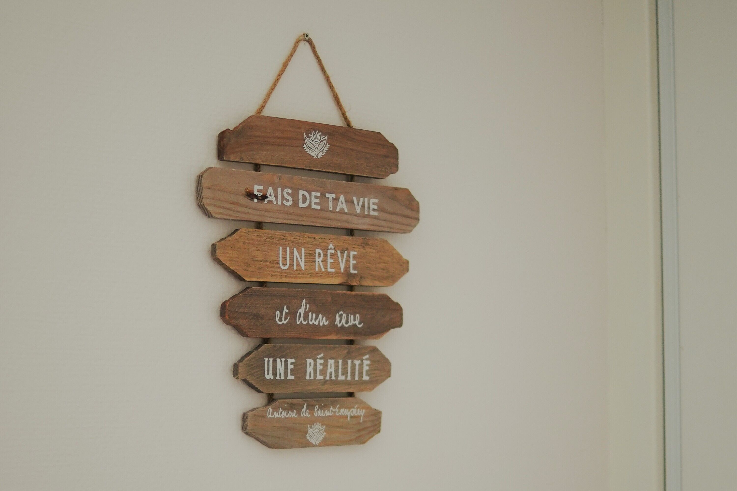 Un letrero de madera con texto en francés.