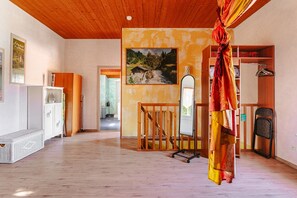 A spacious room with wooden flooring, a staircase, a wardrobe, and a large mirror. - Holiday Home 'Gîte Le Petit Sableau' with Shared Pool & Spa, Private Terrace, Wi-Fi (MARANS)