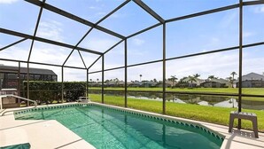 Piscina com vista clara do bairro ao redor, incluindo casas e um corpo d'água.