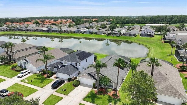 Um bairro residencial com casas, lago e céu claro.