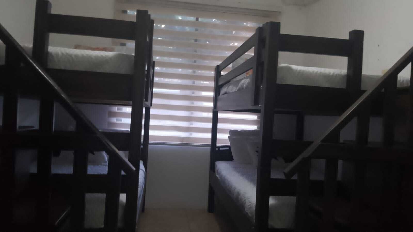 Una habitación con dos literas y una ventana con persianas.