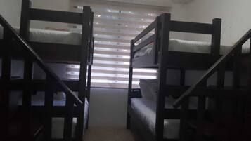 Una habitación con dos literas y una ventana con persianas.