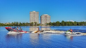 A water body with two high-rise buildings in the background. - Perfect Lakefront Serenity: Private Sunrise Views, just 1 mi. to Disney Springs! (Orlando)