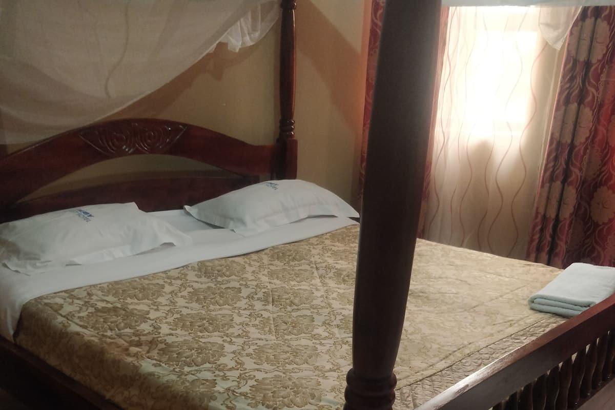 A bed with a wooden frame and a patterned bedspread.