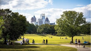 A park with a city skyline in the background, featuring a variety of trees and open grassy areas. - Fully Furnished | Fast Wi-Fi | Midterm Stays Welcome (Atlanta)