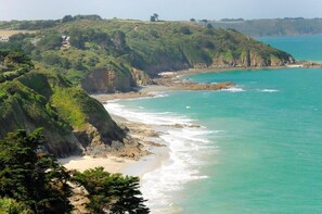 A coastal landscape with a beach, cliffs, and a clear view of the ocean. - Le Coin des Hirondelles (HILLION)