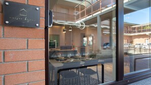 Een restaurant met een bakstenen muur, een glazen raam en een bord met een huissymbool.