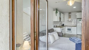 Moderni sisustus, jossa on sohva, lamppu ja näkymä keittiötilaan.