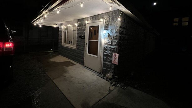 A small building with a garage door, a 'No Parking' sign, and string lights. - Coming into town for any special event.Cozy spacious space with all your needs!  (Mount Pleasant)