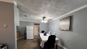 A dining area with a table set for four, a ceiling fan, and a refrigerator in the background. - Coming into town for any special event.Cozy spacious space with all your needs!  (Mount Pleasant)