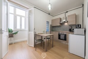 A modern kitchen with wooden cabinets, a dining table, and chairs.