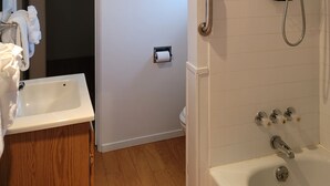 A bathroom with a shower, toilet, sink, and a towel rack. - Mendocino Ocean View Apartment #6 (Mendocino)