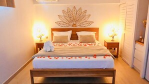 A neatly made bed with a wooden headboard, two bedside tables with lamps, and a decorative wall piece above the bed.
