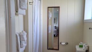 Un baño con inodoro, lavamanos y cabina de ducha.