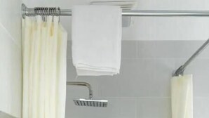 Un espace douche moderne avec une paroi en verre, un porte-serviettes et une barre d’appui en métal.