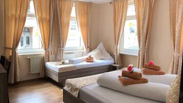 Deluxe Triple Room | Desk, laptop workspace, blackout drapes, iron/ironing board