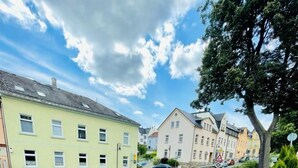 A patio area with outdoor seating and a large umbrella. - Pension Goldenes Vogtland (Adorf)