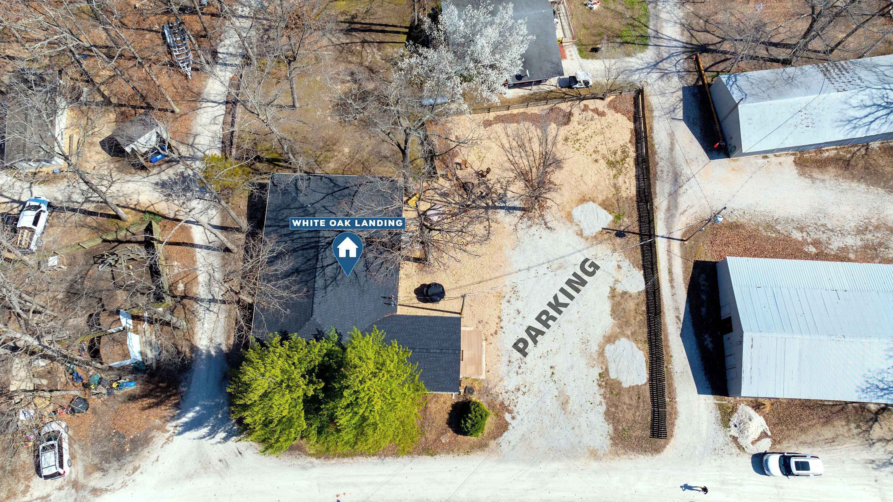 An aerial view of a parking area with a sign for 'WHITE OAK LANDING' and a directional arrow.