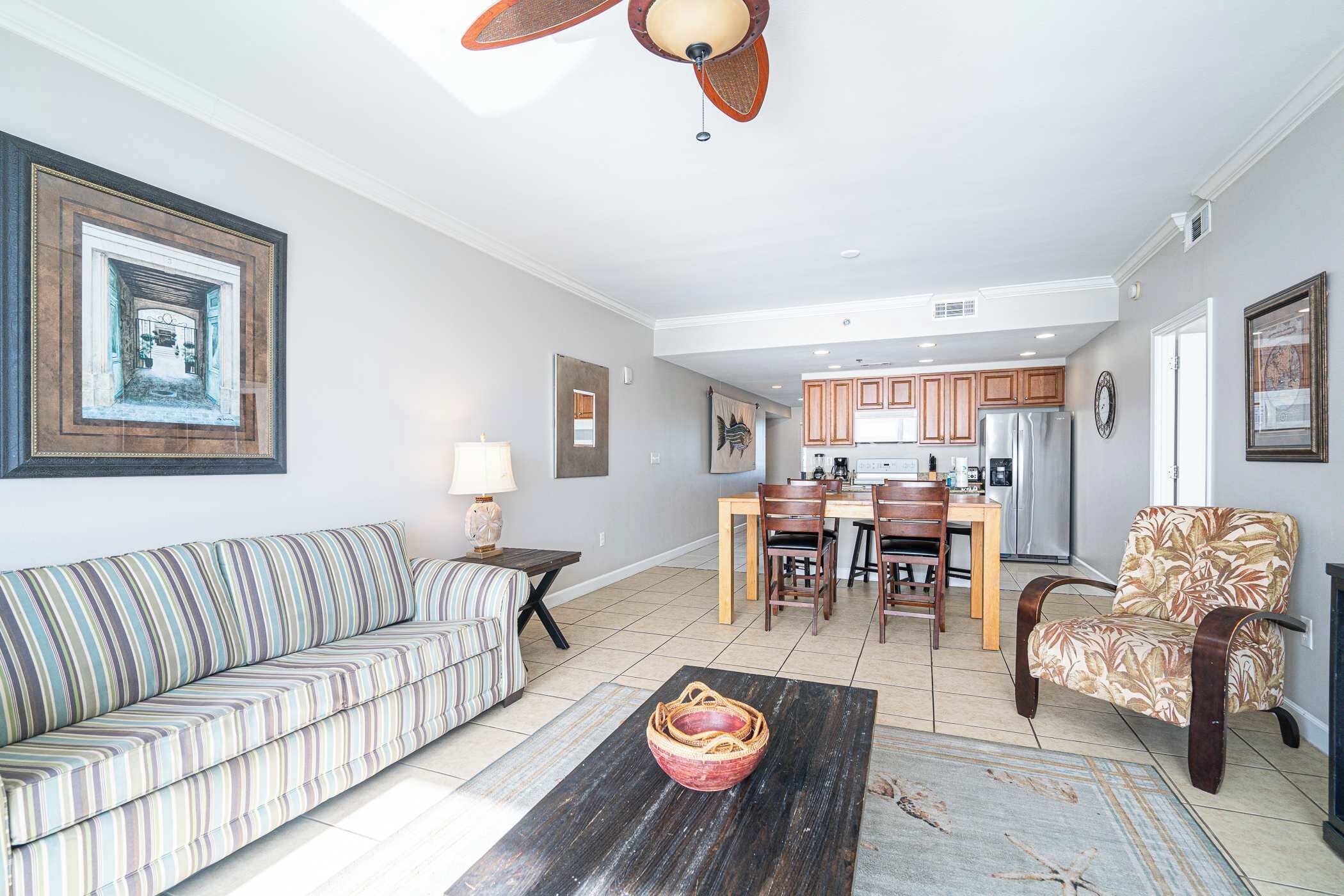 A living room with a sofa, a coffee table, and a dining area with chairs and a table.