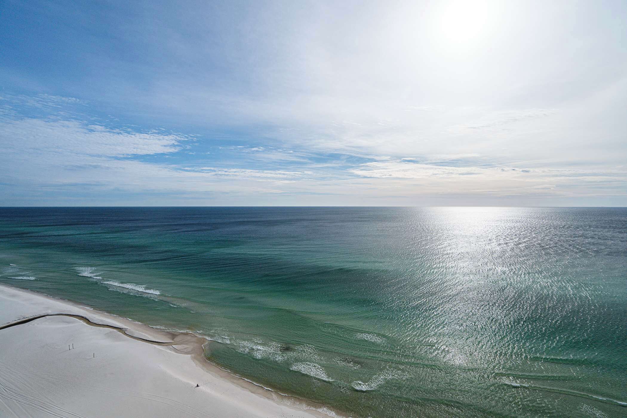 A beach with clear turquoise water and a sandy shore.