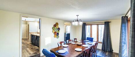 A dining area with a wooden table, chairs, and a chandelier.