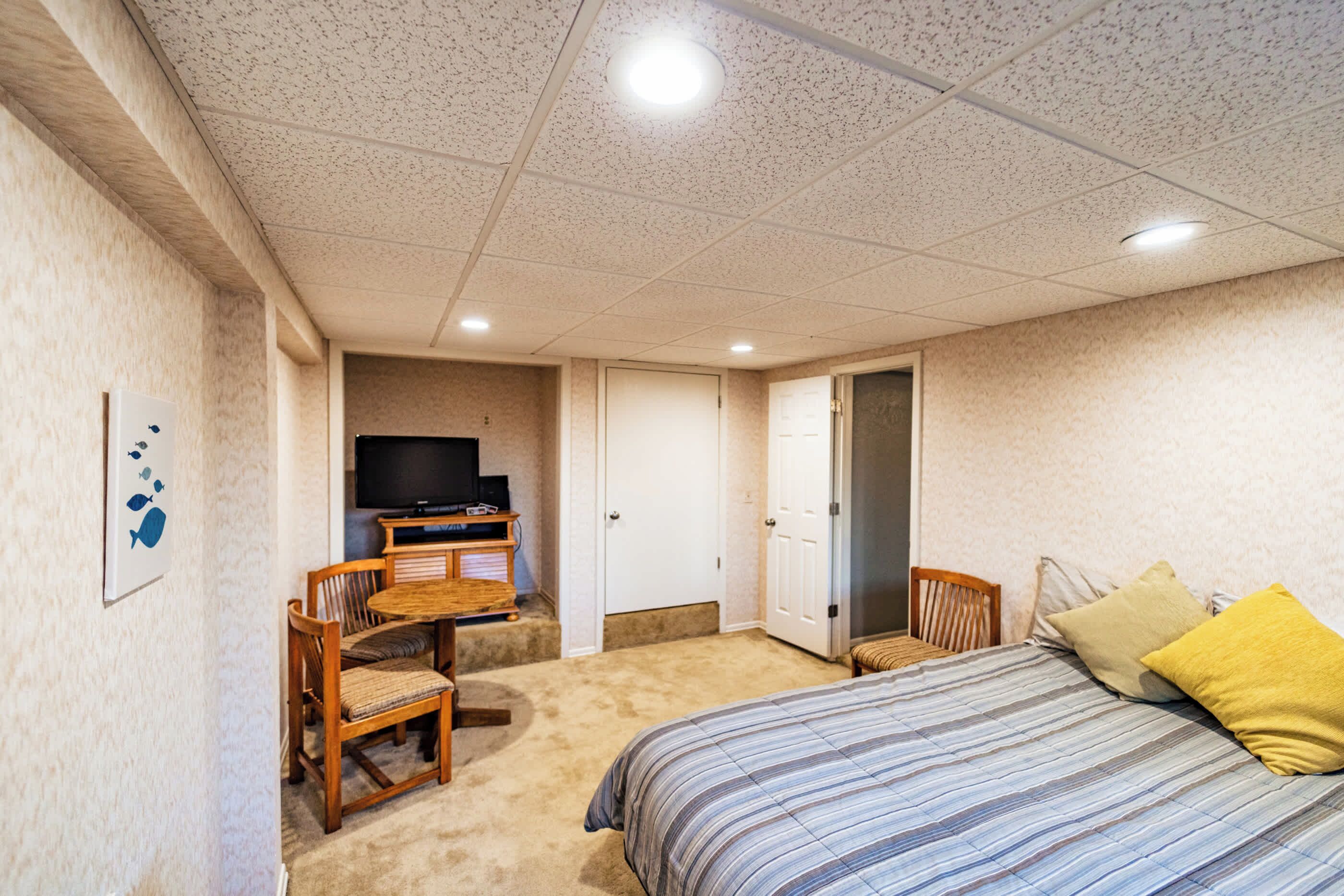 Een slaapkamer met een bed, een televisie, een bureau en een stoel.