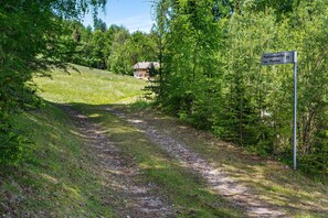 A rural path leading to a house with a sign indicating 'Plattnerwertel Loc. Platten.'