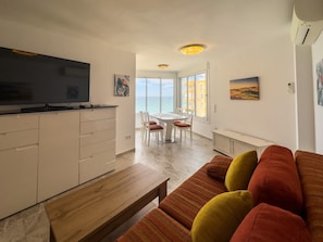 A modern apartment with a kitchen, dining area, and living room.