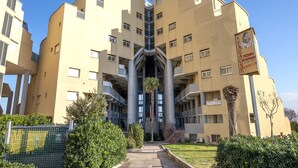 Un immeuble à plusieurs étages doté d’un atrium central, de balcons et d’une enseigne indiquant qu’il s’agit d’une pizzeria.