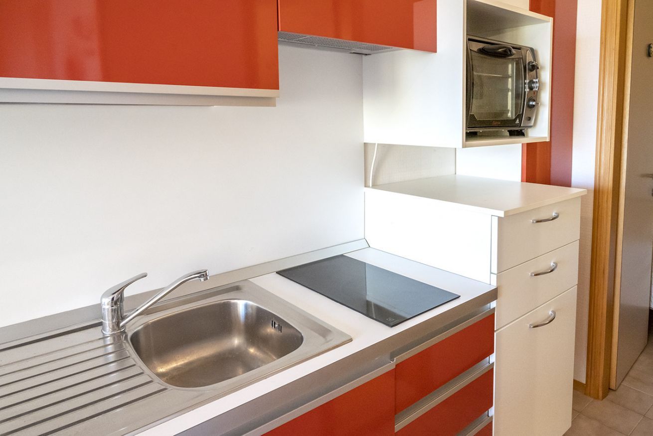 Een keuken met een dubbele spoelbak, een magnetron en een inbouwoven.