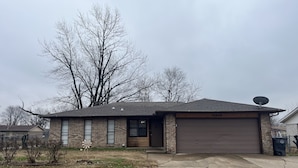 A two-story house with a brick facade, a garage, and a satellite dish. - Great location close to all Tulsa has to offer.  Pet friendly, fenced back yard! (Tulsa)