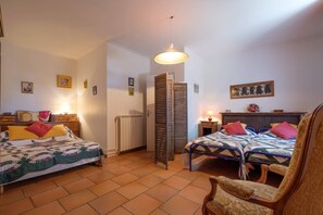 Two single beds, each with a quilt and pillows, are set against a simple backdrop.