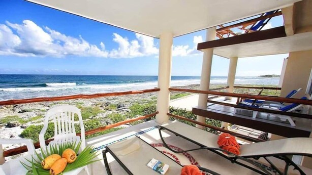 En balkon med havudsigt, et bord med en stol og et håndklæde.