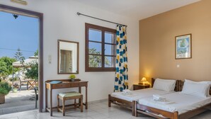 A bedroom with a bed, a desk, a chair, a window with curtains, and a wall-mounted lamp.